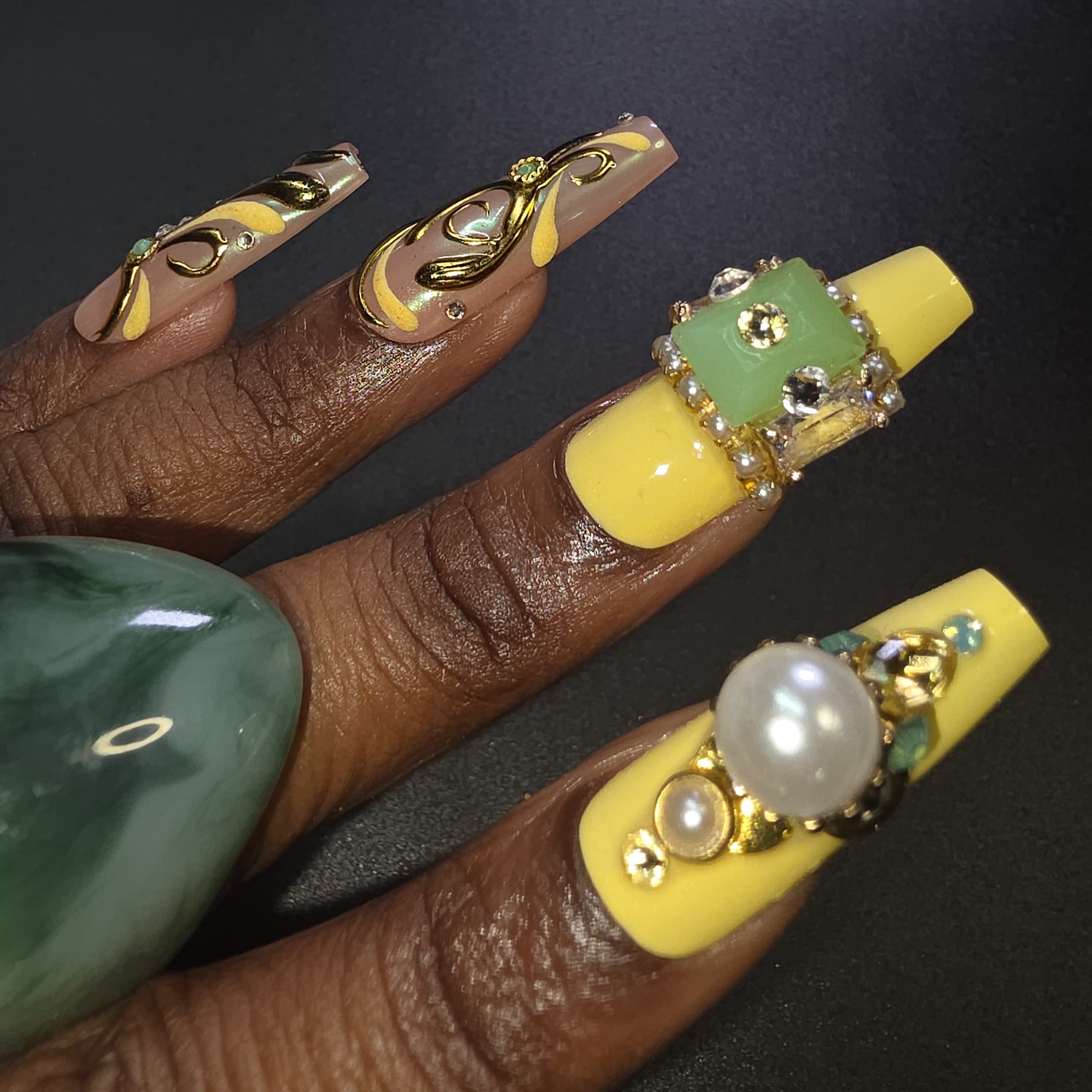 Nails with yellow and decorative design on a dark background