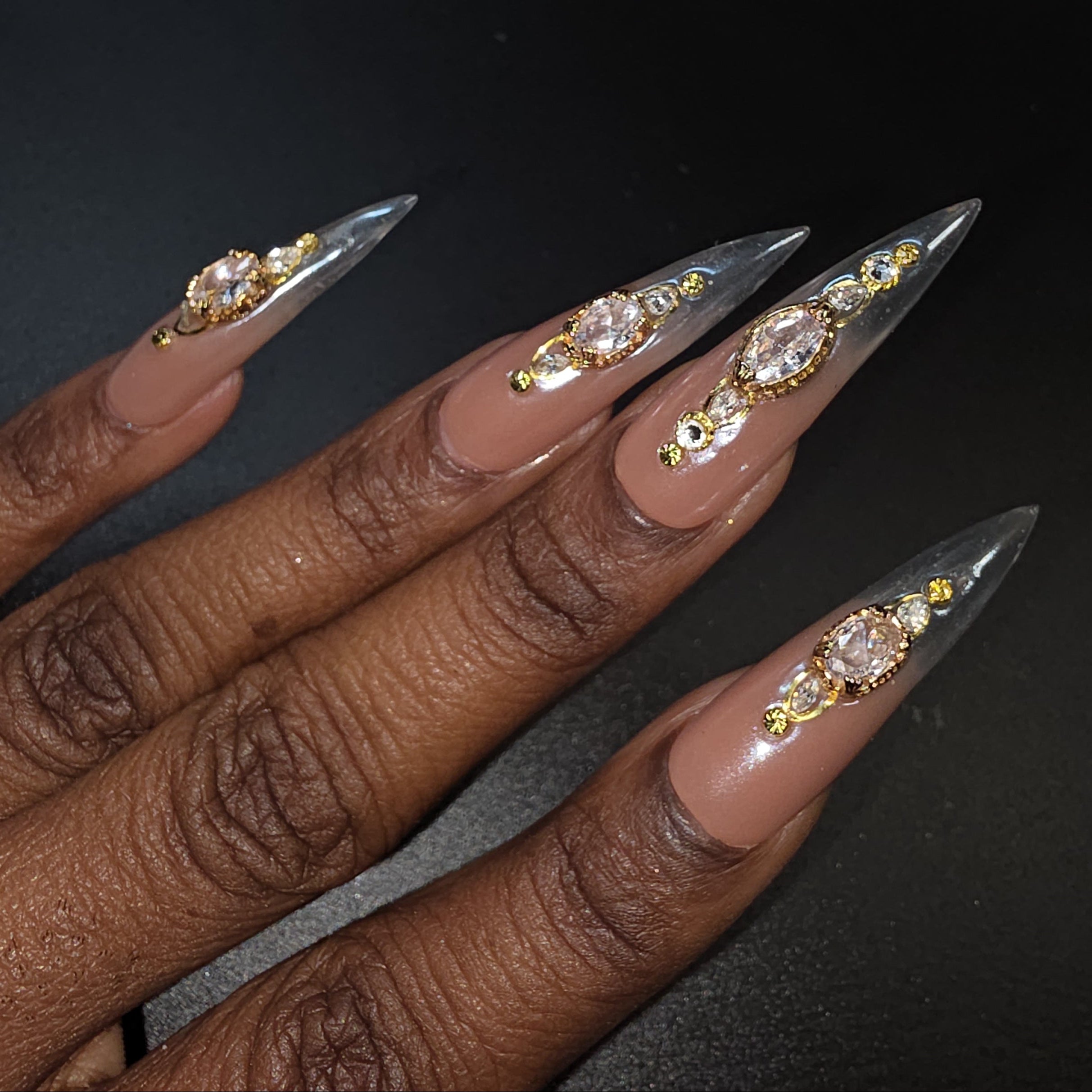 Nail art with decorative stones on a dark background