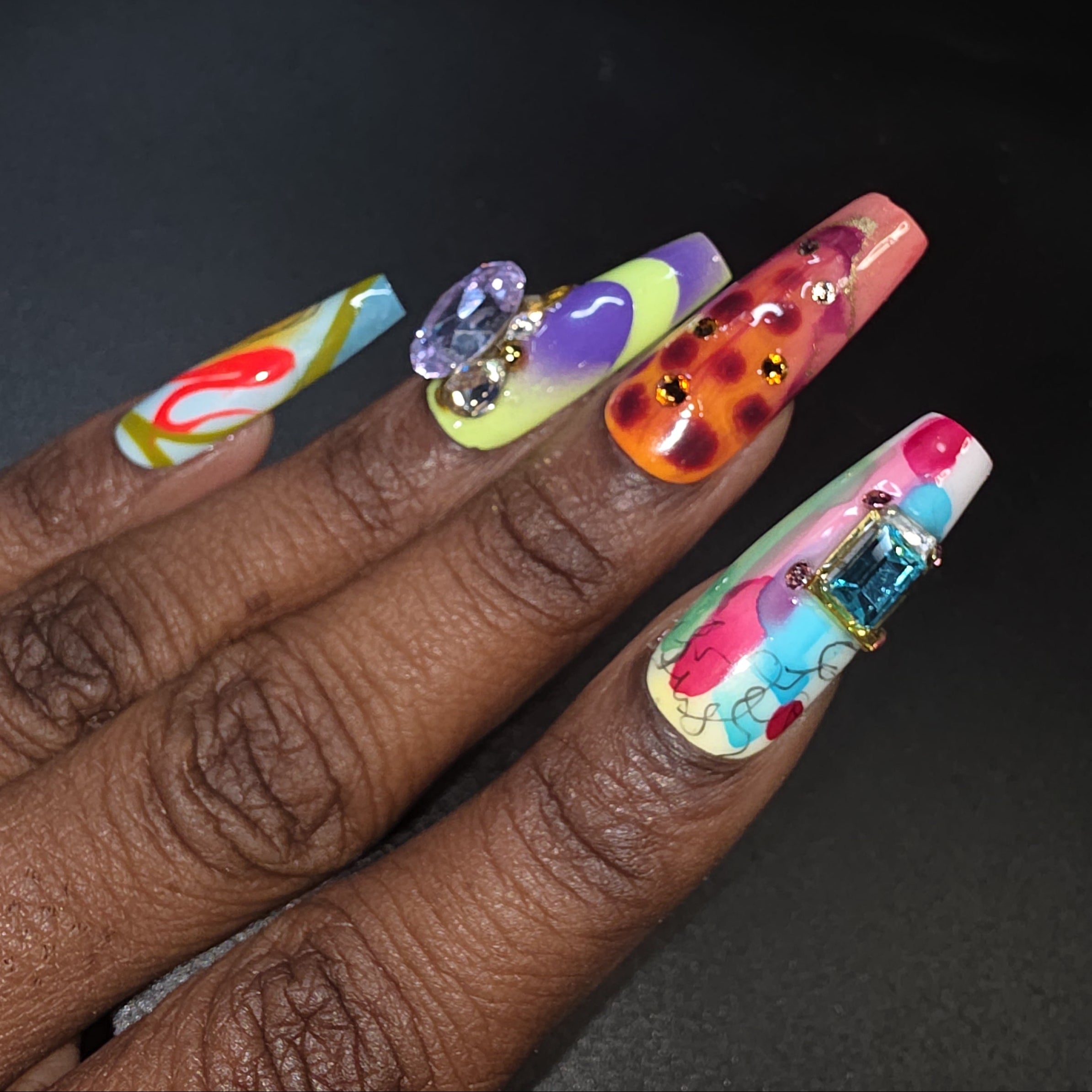 Multicolored nail art with decorative elements on a dark background